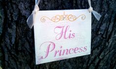 a sign hanging from the side of a tree that says,'his princess '