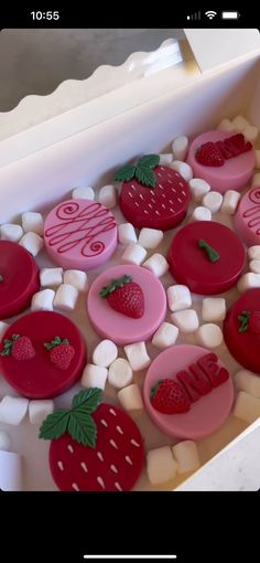 a box filled with lots of different types of buttons and strawberries on top of marshmallows