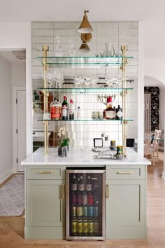 an open refrigerator in a kitchen next to a counter with bottles and glasses on it