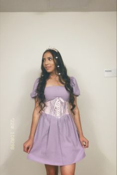 a woman in a purple dress is posing for the camera