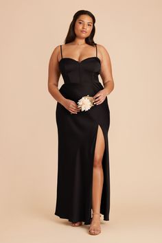 a woman wearing a black dress and holding a bouquet