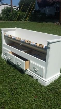 an old dresser turned into a bench in the grass with drawers open on both sides