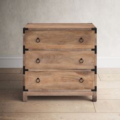 a wooden dresser sitting on top of a hard wood floor next to a white wall