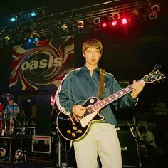 a young man playing an electric guitar on stage