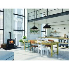 an open concept kitchen and dining room with white brick walls, wood floors and exposed ceilings