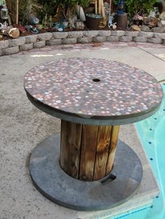 an outdoor table made out of rocks near a pool