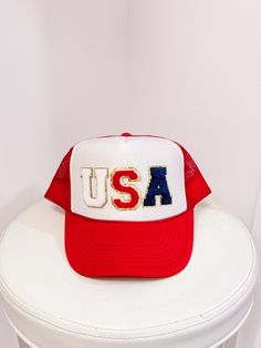 The USA Red Hat from Sassy Shortcake is a Red trucker style mesh hat with a white front and glitter USA text in the center. One size fits most. White Baseball Cap Trucker Hat For 4th Of July, Red Baseball Cap For 4th Of July, White Trucker/basbeall Cap For 4th Of July, Red Patriotic Trucker Hat With Curved Brim, Patriotic Red Adjustable Trucker Hat, Red Baseball Cap Trucker Hat For 4th Of July, Patriotic Red Trucker Hat With Curved Brim, Red Trucker Hat With Letter Print, Red Adjustable Trucker Hat For 4th Of July