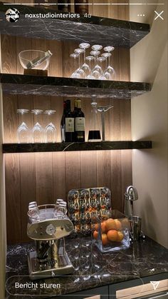 a kitchen counter with wine glasses, oranges and other items on top of it