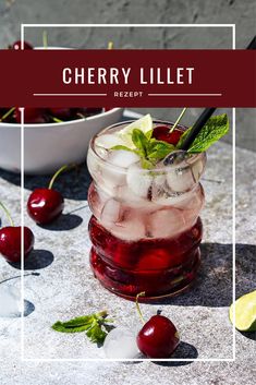 a glass filled with ice and cherries on top of a table