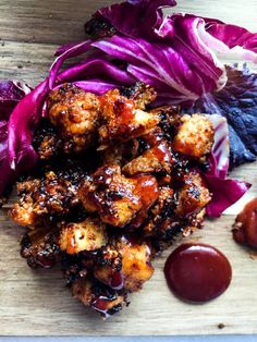 some food that is on top of a cutting board with lettuce and sauce