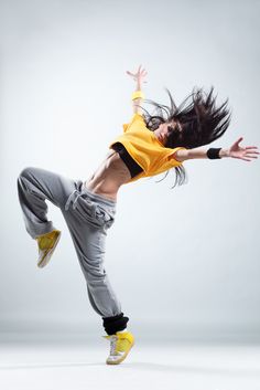 a woman is jumping in the air with her arms out and legs spread wide open