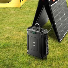 an image of a portable solar panel on the grass with other equipment in the background