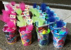 there are many little buckets that have been decorated with different colors and designs on them