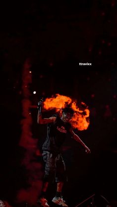 a man standing on top of a basketball court holding a ball in his hand and fire coming from behind him