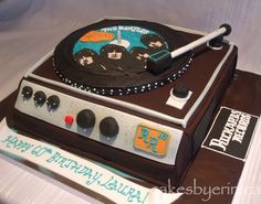 a cake that is shaped like a record player and has the band's logo on it