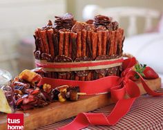 a stack of food sitting on top of a wooden cutting board next to a red ribbon