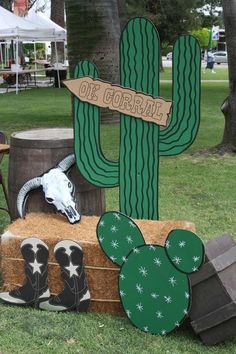 an outdoor display with cactus, cow skull and cowboy boots