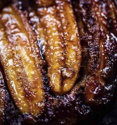 closeup of sliced bananas sitting on top of a pan covered in brown sugar and syrup