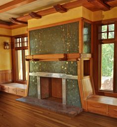 an empty room with wooden floors and green tiles on the wall, along with two windows