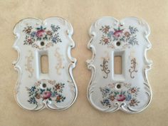 two porcelain switch plates with floral designs on them