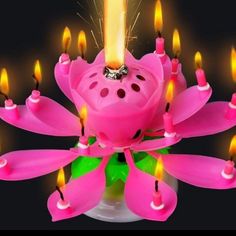 a pink flower shaped candle with lit candles