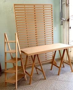 a wooden table and chair sitting next to each other in front of an open window