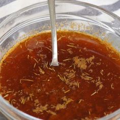 a glass bowl filled with sauce on top of a table