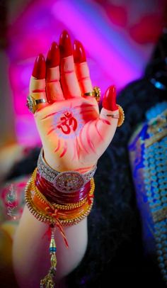 a woman's hand painted with red and white paint holding up her hands in the air