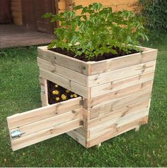 a planter made out of pallets with plants growing in it on the grass