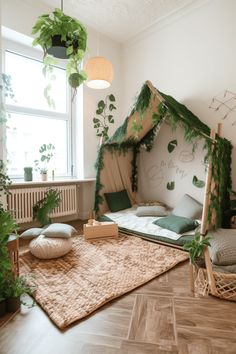 a room with plants and pillows on the floor next to a bed that has a canopy over it