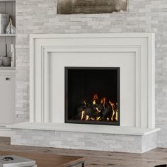 a fire place in the middle of a living room with white brick walls and flooring