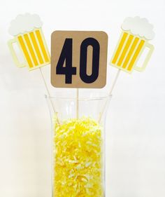 a glass filled with yellow rice and cupcake toppers