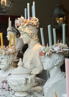 two white statues with candles on top of them