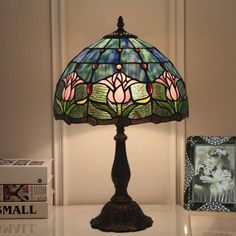 a lamp that is sitting on top of a table next to a box and some books