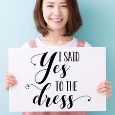 a woman holding up a sign that says i said yes to the dress