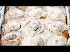 a pan filled with cinnamon rolls covered in icing