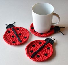 three crocheted ladybug coasters next to a coffee cup