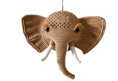 an elephant shaped ornament hanging from a string with eyes on it's head