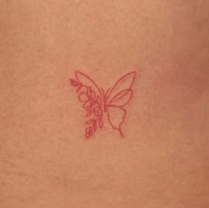 a small butterfly tattoo on the back of a woman's left side ribcage