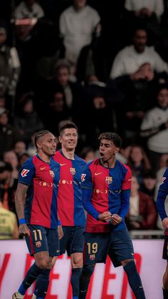 three soccer players are congratulating each other in front of an audience at a sporting event