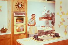 a woman standing next to an oven in a kitchen