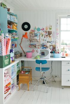 a room filled with lots of crafting supplies and decor on the wall next to a window