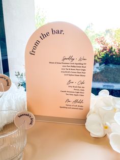 the table is set up with flowers and place cards for guests to write their names