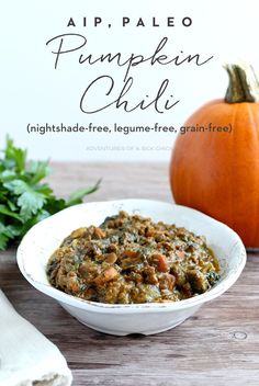 a white bowl filled with food next to a pumpkin