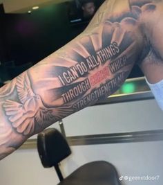 a man's arm with an eagle and bible verse tattoo on his left arm