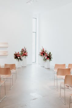 two vases filled with flowers sitting on top of chairs