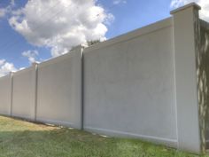 a long white fence is in the grass