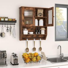 a kitchen with an open cabinet over the sink and utensils hanging on the wall