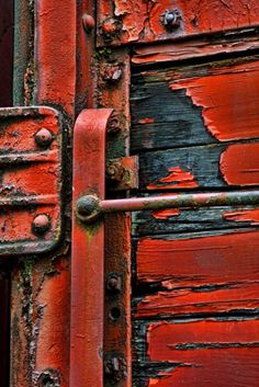 an old red door with rusted metal handles