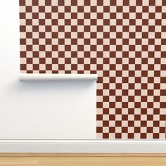 a brown and white checkerboard pattern on the wall next to a wooden floor